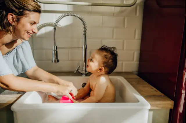 bath a baby in the kitchen sink